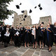 A group of students throwing their hats into the air after graduation
