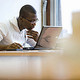 A man reading the student guide on his laptop computer
