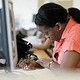 A student filling in a form next to a work station