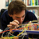 A man plugging in wires, carrying out research